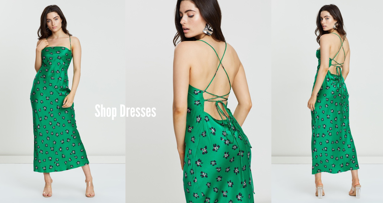 Model is wearing a green satin midi dress with straight neckline, low open back with cross lace up.